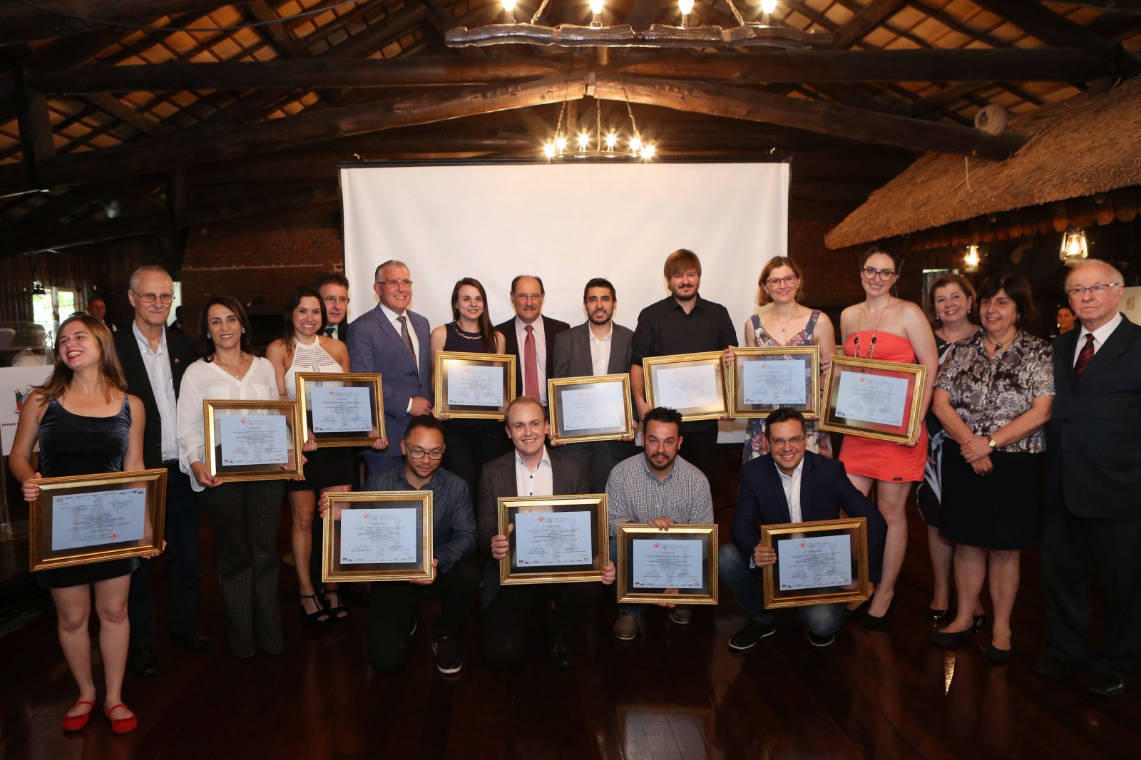 Foto reúne todos os ganhadores do prêmio e autoridades. São cerca de 20 pessoas. Ao centro, o governador José Ivo Sartori e à direita os secretários Isara Marques, Maria Helena Sartori e Odacir Klein. À esquerda, autoridades do segmento.