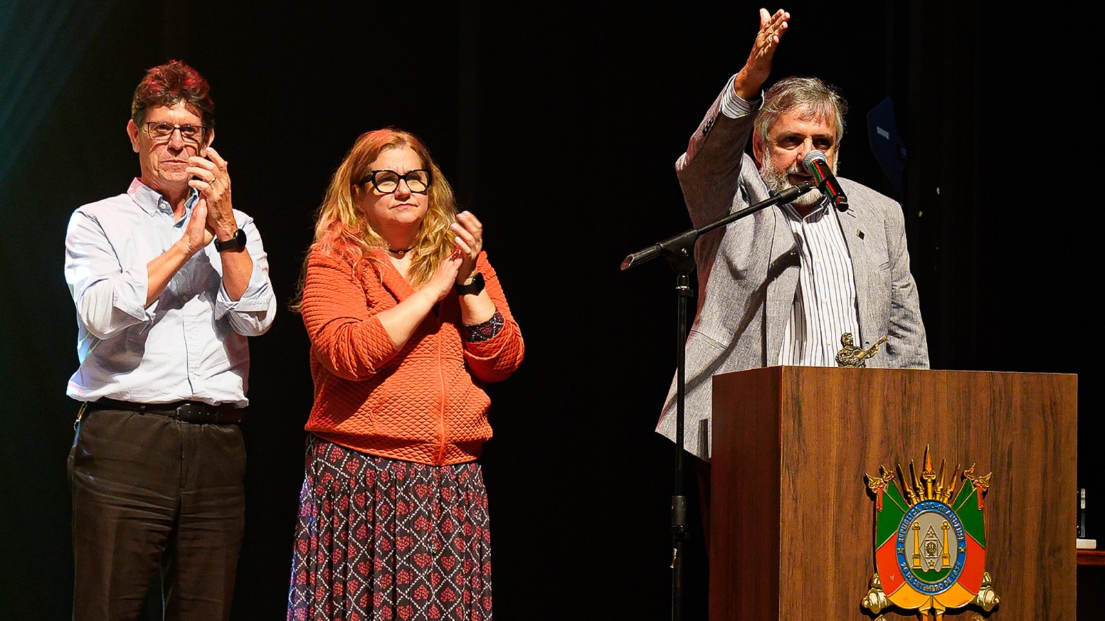No palco estão os três premiados e atrás do pulpito o realizador fala ao público