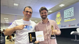 Foto posada do diretor de Redes da Secom segurando o prêmio recebido.